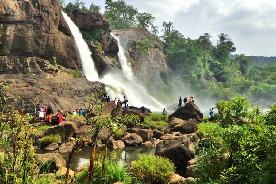 A scenic waterfall surrounded by greenery in Kerala, known for its natural beauty and lush landscapes